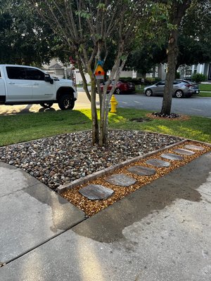 Tree Island Landscape Transformation - A simple upgrade that makes a big impact! 🌳✨ We installed a decorative river rock bed around the tree, added a clean block border, and created a beautiful stepping-stone pathway with decorative gravel. The result is a polished, low-maintenance landscape feature that enhances the home’s curb appeal and adds character to the front yard. Tree Island Landscape Transformation - A simple upgrade that makes a big impact! 🌳✨ We installed a decorative river rock bed around the tree, added a clean block border, and created a beautiful stepping-stone pathway with decorative gravel. The result is a polished, low-maintenance landscape feature that enhances the home’s curb appeal and adds character to the front yard.