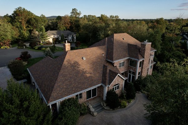 Sedona Canyon Roof Replacement - This beautiful brick colonial was elevated with a full roof replacement featuring warm, earthy tones that perfectly complement the home’s classic style. We installed Owens Corning Duration shingles in Sedona Canyon, which brought a rich blend of browns, coppers, and subtle reds to enhance the brick façade.
The architectural shingles add depth and dimension to the roofline, while also providing long-term protection against the elements. The result? A timeless look that blends seamlessly into the tree-lined cul-de-sac while giving the home standout curb appeal. Sedona Canyon Roof Replacement - This beautiful brick colonial was elevated with a full roof replacement featuring warm, earthy tones that perfectly complement the home’s classic style. We installed Owens Corning Duration shingles in Sedona Canyon, which brought a rich blend of browns, coppers, and subtle reds to enhance the brick façade.
The architectural shingles add depth and dimension to the roofline, while also providing long-term protection against the elements. The result? A timeless look that blends seamlessly into the tree-lined cul-de-sac while giving the home standout curb appeal.