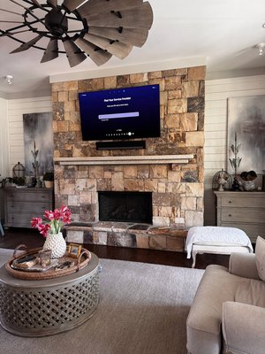 Fireplace & Outdoor TV Mounting with Soundbar | Clean, Professional Installations with Hidden Wiring — Atlanta Home Upgrade Project - What We Did:
🔸 1. Indoor Setup — Fireplace TV Mounting with Soundbar
Installed a large flat-panel TV directly onto a stacked stone fireplace facade.

Secure mounting to accommodate weight and maintain alignment on uneven stone.

Installed and centered a soundbar directly under the TV for a theater-like experience.

Routed power and signal cables behind the stone mantle with full concealment.

Verified thermal clearance and safe mounting above the fireplace opening.

🔸 2. Outdoor Setup — Covered Patio TV Installation
Mounted a second TV on an exterior lap-siding wall in a semi-enclosed outdoor area.

Used weather-resistant anchors and ensured proper ventilation.

Routed all wiring internally with no visible cords or external conduits.

Final positioning allows for optimal viewing from the patio lounge zone.

✅ Result:
Both TVs look completely integrated into their spaces. The fireplace TV setup feels immersive thanks to the added soundbar, while the outdoor installation delivers a clean and solid finish that blends with the siding. All wires are hidden, and both areas are now fully entertainment-ready.