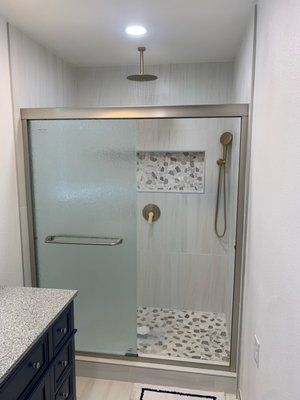 Bathroom Remodel - This remodel was done for a returning client who's secondary bathroom we renovated a few years ago. Client wanted to expand bathroom. Bathroom and closet were divided by one wall so we relocated the closet and bathroom absorbed the closet space to enlarge restroom area. This project was a full renovation including new texture, paint, lighting, exhaust fan, commode, vanity/ mirror, floor tile and shower conversion.