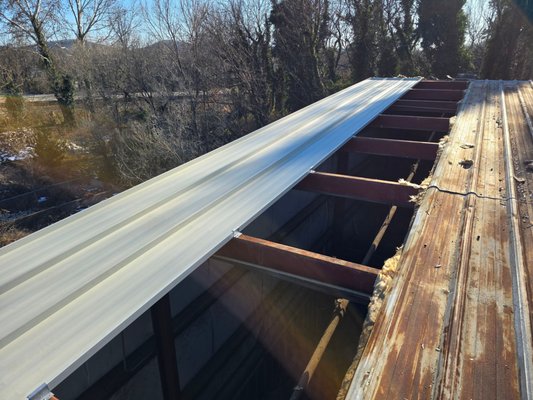 Roof replacement - Vertex Roofing is laying down brand new standing seam panels on this warehouse roof—custom made on site, cut to length, and ready to last Roof replacement - Vertex Roofing is laying down brand new standing seam panels on this warehouse roof—custom made on site, cut to length, and ready to last