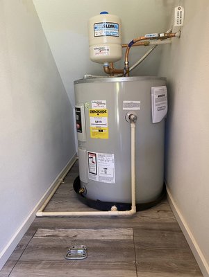 Bradford White 50 gallon “low boy” electric water heater - Client reported no hot water and water leaking from Water Heater. The water had destroyed the floor and the sheet rock walls. We removed the old water heater after the sheet rock. Walls and floors were replaced. We installed a new water heater as shown with a new containment pan and a drowned router to the exterior in the future. Any water that leaks from this Water Heater will be carried away to the outside. .