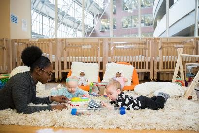 Infant Programs - A new addition to our facility in 2018, our Infant Program offers a second home environment for 14 infants ages 3 months to 15 months. The program includes two classrooms, each licensed for seven children daily. Attachment is one of the most important factors to consider for infants and is believed to influence relationships with others later in life. For this reason, we have three full-time professional staff members in each classroom so that the children in our care can form deep attachments and trust with a primary caregiver.
Our Infant One and Infant Two classrooms have been designed to calm babies’ senses by providing a safe, loving, warm, and rich environment where each receives individual time to engage in learning and is given the emotional support needed to thrive. Teachers spend individual time with each infant providing learning experiences, and feeding, diapering, and dressing them. They also ensure that enough quiet time and rest time are provided. There is always special time for cuddling or rocking throughout the day. All of these experiences build upon the trust and bond between the infant and caregiver.
Infants need predictability, so a regular routine and relationships are provided. Teachers work closely with parents even before their infant joins the classroom to discuss when their baby is fed, diapered, dressed, sleeps, and plays. In this way, every infant’s individual needs are met and they stay on their own schedule. Each baby’s individual daily activity is based on his or her evolving pattern of playing, eating, and sleeping. While this routine may be similar at home and at the Center, it is natural—given the classroom setting’s group dynamics—that the infant might follow a slightly different schedule at TCC. Teachers communicate closely with parents to find each child’s daily rhythm and partner with families to regulate the child’s pattern and routine.
Infants are naturally curious, and they are driven to explore and to practice new skills. They learn through all their senses by touching, smelling, hearing, seeing, and tasting. By providing developmentally appropriate materials, rich experiences, and a nurturing environment, our teaching staff helps them learn about the world around them and gain knowledge that promotes future learning. The curriculum is based on the Massachusetts Early Learning Guidelines for Infants and Toddlers; infants will be assessed every three months based on these standards.
The infants in our care are given plenty of time for tummy time and time on the floor to build self-confidence and physical control with a teacher’s guidance and supervision. When exploring the environment, the infant becomes a creative, self-motivated, and curious learner early on. Singing, reading, talking, and playing are daily classroom activities. American Sign Language is incorporated to help the infants and teachers communicate with one another. Infants will develop at their own pace and teachers will be there to support this natural process.
Recent brain development research has given us valuable information. We now know that while the physical brain is developed at birth, children’s early experiences have an enormous influence on brain development. The infants in our care are provided both positive interactions and formative experiences during this important stage of development, thereby strengthening and having a significant impact on their emotional, social, cognitive, and physical well-being through life. Infant Programs - A new addition to our facility in 2018, our Infant Program offers a second home environment for 14 infants ages 3 months to 15 months. The program includes two classrooms, each licensed for seven children daily. Attachment is one of the most important factors to consider for infants and is believed to influence relationships with others later in life. For this reason, we have three full-time professional staff members in each classroom so that the children in our care can form deep attachments and trust with a primary caregiver.
Our Infant One and Infant Two classrooms have been designed to calm babies’ senses by providing a safe, loving, warm, and rich environment where each receives individual time to engage in learning and is given the emotional support needed to thrive. Teachers spend individual time with each infant providing learning experiences, and feeding, diapering, and dressing them. They also ensure that enough quiet time and rest time are provided. There is always special time for cuddling or rocking throughout the day. All of these experiences build upon the trust and bond between the infant and caregiver.
Infants need predictability, so a regular routine and relationships are provided. Teachers work closely with parents even before their infant joins the classroom to discuss when their baby is fed, diapered, dressed, sleeps, and plays. In this way, every infant’s individual needs are met and they stay on their own schedule. Each baby’s individual daily activity is based on his or her evolving pattern of playing, eating, and sleeping. While this routine may be similar at home and at the Center, it is natural—given the classroom setting’s group dynamics—that the infant might follow a slightly different schedule at TCC. Teachers communicate closely with parents to find each child’s daily rhythm and partner with families to regulate the child’s pattern and routine.
Infants are naturally curious, and they are driven to explore and to practice new skills. They learn through all their senses by touching, smelling, hearing, seeing, and tasting. By providing developmentally appropriate materials, rich experiences, and a nurturing environment, our teaching staff helps them learn about the world around them and gain knowledge that promotes future learning. The curriculum is based on the Massachusetts Early Learning Guidelines for Infants and Toddlers; infants will be assessed every three months based on these standards.
The infants in our care are given plenty of time for tummy time and time on the floor to build self-confidence and physical control with a teacher’s guidance and supervision. When exploring the environment, the infant becomes a creative, self-motivated, and curious learner early on. Singing, reading, talking, and playing are daily classroom activities. American Sign Language is incorporated to help the infants and teachers communicate with one another. Infants will develop at their own pace and teachers will be there to support this natural process.
Recent brain development research has given us valuable information. We now know that while the physical brain is developed at birth, children’s early experiences have an enormous influence on brain development. The infants in our care are provided both positive interactions and formative experiences during this important stage of development, thereby strengthening and having a significant impact on their emotional, social, cognitive, and physical well-being through life.