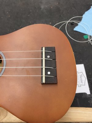 Ukulele Repair - A piece of the bridge had broken off so I carved a new piece, glued it in, and restrung the uke. Ukulele Repair - A piece of the bridge had broken off so I carved a new piece, glued it in, and restrung the uke.