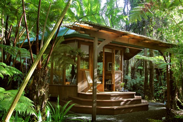 Sanctuary Cottage - For a unique Big Island B&B lodging experience secluded deep in the Volcano rainforest, stay in our small romantic hexagon cedar sanctuary, embraced by lush tree ferns and ethereal mist. Step into an intimate Japanese country style interior with low tables, indigo bedding and floor cushions. Shoji doors open to a small toilet room with cozy robes and bath towels. Relax on sitting chairs by the gas fireplace or rest on the queen bed gazing through floor to ceiling glass windows and savor enchanting forest views. In the filtered morning light, enjoy the small kitchen nook and delight in a private breakfast provided the night before.
Become one with nature in the private bathhouse with outdoor shower and handcrafted o’furo (traditional Japanese hot tub). Soak in the Volcano experience of the primal and sacred. Perfect for couples or singles who enjoy small, intimate places and the uniqueness of showering outside in the native forest. Available for solitary meditation retreats in seclusion
Amenities
Intimate hexagon design
200 sq. ft. of charming living space
Queen Bed
Floor to ceiling windows and forest views
Breakfast in the privacy of your own cottage
Kitchen nook with bar sink, small refrigerator
No cooking facilities
Small toilet room, sink in kitchenette
Private Japanese o’furo hot tub
Outside shower & bamboo blinds for privacy
Shower products, hairdryer
Warm comfortable robes
Romantic gas fireplace
Wine glasses and bottle opener
High-Speed Wireless Internet
DVD & CD selection
Iron and ironing board
Flashlights and headlamps
Safe for valuables
Guest parking in main carport Sanctuary Cottage - For a unique Big Island B&B lodging experience secluded deep in the Volcano rainforest, stay in our small romantic hexagon cedar sanctuary, embraced by lush tree ferns and ethereal mist. Step into an intimate Japanese country style interior with low tables, indigo bedding and floor cushions. Shoji doors open to a small toilet room with cozy robes and bath towels. Relax on sitting chairs by the gas fireplace or rest on the queen bed gazing through floor to ceiling glass windows and savor enchanting forest views. In the filtered morning light, enjoy the small kitchen nook and delight in a private breakfast provided the night before.
Become one with nature in the private bathhouse with outdoor shower and handcrafted o’furo (traditional Japanese hot tub). Soak in the Volcano experience of the primal and sacred. Perfect for couples or singles who enjoy small, intimate places and the uniqueness of showering outside in the native forest. Available for solitary meditation retreats in seclusion
Amenities
Intimate hexagon design
200 sq. ft. of charming living space
Queen Bed
Floor to ceiling windows and forest views
Breakfast in the privacy of your own cottage
Kitchen nook with bar sink, small refrigerator
No cooking facilities
Small toilet room, sink in kitchenette
Private Japanese o’furo hot tub
Outside shower & bamboo blinds for privacy
Shower products, hairdryer
Warm comfortable robes
Romantic gas fireplace
Wine glasses and bottle opener
High-Speed Wireless Internet
DVD & CD selection
Iron and ironing board
Flashlights and headlamps
Safe for valuables
Guest parking in main carport