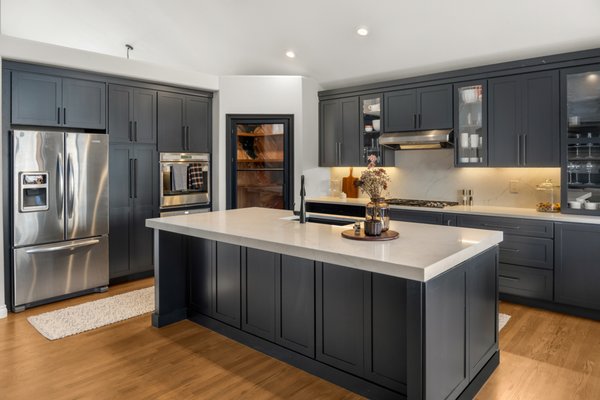 South Miller Court Kitchen Remodel, Littleton - This Littleton kitchen remodel introduced a completely reconfigured layout centered around a spacious, multifunctional island. Deep charcoal cabinetry, bright quartz countertops, warm wood accents, integrated pantry storage, updated lighting, and relocated plumbing create a sophisticated kitchen designed for effortless everyday living.