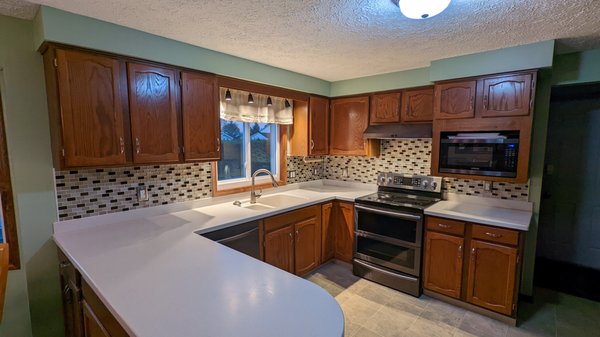 Glass Backsplash - This customer had removed a brick backsplash that he described as awful. He repaired the walls on his own but wanted a modern glass backsplash installed.  We installed this beautiful backsplash for the client including adjusting the outlets and installing new outlet covers.