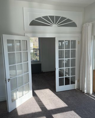 French Doors and Transom windows - Client asked for a partition in his living room converting the extra space into a nursery room for his new born. We decided on a wall partition including double wooden French doors with transom window on top to help distribute natural sunlight through the glass design. Overall one our favorite small projects, the final product speaks for itself.