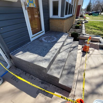New Front Steps / Pad - Early 2022 full replacement of front steps and pad. Colored and stamped with a unique compass impression pointing due north. The project took one day to breakdown the old set and a second day to pour and stamp. We were in and out in 3 days total during the middle of the week. This front entrance is now a unique, creative welcoming piece for guests and the homeowner alike.