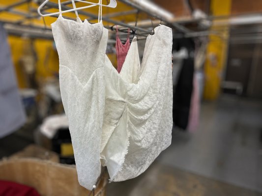 Chantilly Lace Wedding Gown Cleaning - A bride brought us her all-over Chantilly lace gown from Mon Amie Bridal Salon with the hem and train gray from the reception floor. Dirt was ground into the delicate scalloped lace edge and the train lining. Chantilly lace sits on a fine net that tears easily, so the entire lower third was hand cleaned with fabric-specific solutions, no machine agitation and no harsh bleaching. The gown came back to bright ivory with every bit of the eyelash lace edge intact, ready for preservation. We clean and preserve wedding gowns with free pickup and delivery in Irvine, Newport Beach, Tustin, and Santa Ana.
