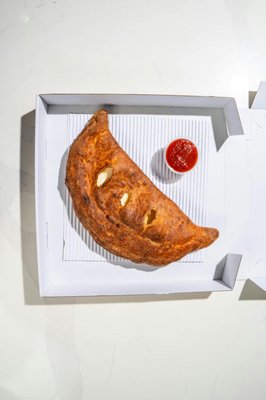 Calzone - Ricotta and mozzarella cheese wrapped in dough.
Customize with your favorite toppings for an added burst of flavor! Calzone - Ricotta and mozzarella cheese wrapped in dough.
Customize with your favorite toppings for an added burst of flavor!