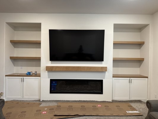 Entertainment Wall - This homeowner wanted to spruce up her living room with a custom Entertainment Wall. We were able to work with her contractor to design this beautiful and functional TV wall. The customer opted for two colors when it came to the shelves and cabinets. You can't go wrong mixing Painted Linen with Maple Rye!