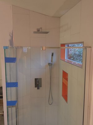 Shower stall upgrade in Norcross, Georgia. - Client loved their bathroom but was unhappy with the size, and tile finishes in this modern style home. We then did our best to capture their vision by ornate shapes, openings and windows, as well as a bright vibrant orange tile. Wow! what a difference.