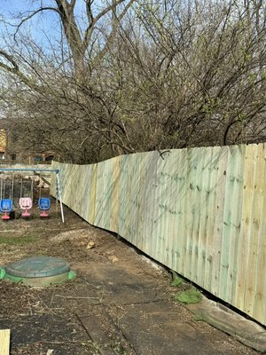 First Privacy Fence Install of 2024 - This Privacy fence was run along the neighbors chain link fence. Client asked to hold pickets off the ground enough to be able to trim plant growth under the fence easily. Fence follows the contour of the yard to keep it looking clean and even. The end of the fence stopped at clients rear chain link fence but left a gap between the end and a privacy section the client installed years prior. To fill the gap, there was a 4ft piece of picket installed to prevent neighbor kids from sneaking into clients yard and damaging the swing set. First Privacy Fence Install of 2024 - This Privacy fence was run along the neighbors chain link fence. Client asked to hold pickets off the ground enough to be able to trim plant growth under the fence easily. Fence follows the contour of the yard to keep it looking clean and even. The end of the fence stopped at clients rear chain link fence but left a gap between the end and a privacy section the client installed years prior. To fill the gap, there was a 4ft piece of picket installed to prevent neighbor kids from sneaking into clients yard and damaging the swing set.