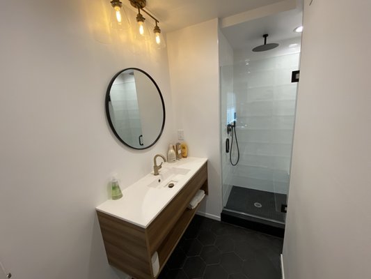 Bathroom remodel and extension. 2020 - This bathroom was in rough shape to begin with. We expanded the stand up shower into the old closet to create a bigger space and maximize our options. We relocated the toilet and the vanity on slab floor which made us do some digging. The outcome was beautiful and included a stand up shower with a sitting bench, shampoo niche, white tile, hand held and separate large shower head. The finished bathroom also included a floating vanity, brass light fixture and honeycomb black tile flooring. Bathroom remodel and extension. 2020 - This bathroom was in rough shape to begin with. We expanded the stand up shower into the old closet to create a bigger space and maximize our options. We relocated the toilet and the vanity on slab floor which made us do some digging. The outcome was beautiful and included a stand up shower with a sitting bench, shampoo niche, white tile, hand held and separate large shower head. The finished bathroom also included a floating vanity, brass light fixture and honeycomb black tile flooring.