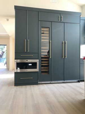 Kitchen Hayreh Pasadena Custom Kitchen Cabinetry in Farrow and Ball Studio Green Custom Finish - Full tear down remodel in Pasadena of the client's existing home. Client wanted to match bespoke British paintmakee FARROW AND BALL STUDIO GREEN. We created an eco-friendly custom color match finish coating rated for kitchens. Next she showed us a drawer and door style she saw online. Our doormaker created custom prototypes to match the English bespoke furniture style of celebrated Michigan interior designer Jean Stoffer.  Our designer Jeannie and team built and incorporated features including custom appliance panels for the wine fridge, refrigerator, dishwasher, and freezer, custom made and hand oiled butcher block slide out cutting board, double trash containers with wood holders, spice rack, custom made and fitted cutler, silverware and utensil tray for the drawers, baking tray dividers, in cabinet lift up mixer stand with butcher block top shelf, rollout  interior tray drawers, lift up countetop appliance garage door and corner door, slide out rack, custom  fitted wood microwave frame, and custom buffet with wire grille door.  Crafted For Me.  Cabinetry Furniture Millwork. CFM Design Inc.