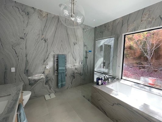 Primary Bath wrapped in Dolomite - This full home remodel featured a primary bath fully wrapped in stone. The material was 2cm Cote D'Azur Dolomite. The scope included floor to ceiling stone throughout and included a vanity, tub deck, and windowsill. The team did a great job laying out the 4 slabs in a way to have the veining continuous between all pieces to make the seams virtually unseeable. Primary Bath wrapped in Dolomite - This full home remodel featured a primary bath fully wrapped in stone. The material was 2cm Cote D'Azur Dolomite. The scope included floor to ceiling stone throughout and included a vanity, tub deck, and windowsill. The team did a great job laying out the 4 slabs in a way to have the veining continuous between all pieces to make the seams virtually unseeable.