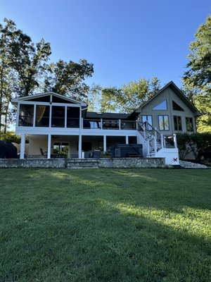 Deck, Porch, and Patio 2024 - We designed an all new deck and porch with dry ceilings below to create a gorgeous new dry patio space below. This full rebuild was done after we removed an old deck that was in bad shape. The customer wanted something big and beautiful to enjoy for years to come!  The deck and porch were done with Trex Lineage composite decking, Trex Transcends rails, and a full white PVC trim wrap. The patio below features finished white ceilings, ceiling fans, and a new storage area below the stairs. Photos taken after a full power wash cleaning!