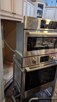 Expert Repair: Bosch Double Wall Oven & Microwave Combo - This project showcases a common challenge for homeowners with modern, high-end kitchens: a complex Bosch double wall oven and microwave combo that had stopped heating. Replacing a unit like this can cost thousands of dollars, making a professional, expert repair the best solution.

Our process for these large, integrated appliances is meticulous and safe. As you can see in the photos, we use specialized lift equipment to carefully remove the entire heavy unit from the wall. This prevents any damage to your cabinetry and floors and allows our technician to perform a full, comprehensive diagnostic to find the root of the problem.

In this case, the issue was traced to a faulty main control board. After replacing the component with a new part, the oven was thoroughly tested and reinstalled perfectly.

The result: a delighted customer who saved a significant amount of money and has their beautiful kitchen back to full working order. We have the expertise and the right equipment to handle even the most complex appliance repairs.