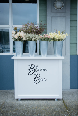 Bloom Bar - A Bloom Bar is a curated display of locally grown flowers for your guests to choose from and create a beautiful bouquet. Our Bloom Bartender guides your guests through the creative and thoughtful process of floral arrangements. These hand-crafted bouquets from our Bloom Bar are a statement at your event, and in the homes of your guests after. Bloom Bar - A Bloom Bar is a curated display of locally grown flowers for your guests to choose from and create a beautiful bouquet. Our Bloom Bartender guides your guests through the creative and thoughtful process of floral arrangements. These hand-crafted bouquets from our Bloom Bar are a statement at your event, and in the homes of your guests after.