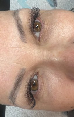 Hybrid Lash Set - Hybrid Eyelash Extensions
The Perfect Balance of Natural & Glamorous
What are Hybrid Lash Extensions?
Hybrid lash extensions combine the best of both worlds by mixing classic single lashes with volume fans in one seamless application. This technique creates a textured, multi-dimensional look that's fuller than classic but more natural than full volume - giving you the perfect balance between enhancement and drama.
The Hybrid Technique:
Strategic Mix Approach
50-70% classic single lashes for natural definition
30-50% volume fans (typically 2D-4D) for added fullness
Customized placement based on your eye shape and natural lash pattern
Textured Application Method
Classic lashes provide length and separation
Volume fans fill gaps and add density
Creates natural-looking texture and dimension
Key Features:
✨ Best of Both Worlds - Natural definition meets glamorous fullness ✨ Customizable Ratio - Adjust classic-to-volume ratio based on desired look ✨ Textured Appearance - Multi-dimensional, naturally full effect ✨ Versatile Styling - Perfect for both everyday and special occasions ✨ Gap-Filling Power - Volume fans address sparse areas while maintaining natural look ✨ Balanced Weight - Fuller than classic but lighter than full volume
Perfect For:
Clients who want more than classic but less than full volume
Those with uneven natural lash density
Anyone seeking a versatile, "your lashes but better" look
Clients transitioning from classic to volume
Busy lifestyles requiring day-to-night versatility
Those who want noticeable enhancement without obvious extensions
Hybrid vs Other Techniques:
vs Classic:
Fuller and more dimensional
Better coverage for sparse areas
More dramatic without being overwhelming
vs Volume:
More natural and wearable daily
Faster application time
Less maintenance intensive
More cost-effective
Application Process:
Time Required: 90-150 minutes for initial full set
Skilled Technique: Requires expertise in both classic and volume methods
Artistic Eye: Strategic placement for optimal natural-looking fullness
Customized Design: Tailored ratio based on your natural lashes and preferences
Styling Options:
Natural Hybrid - More classic lashes, fewer volume fans Glamorous Hybrid - More volume fans, fewer classic lashes Wispy Hybrid - Alternating lengths for feathery, textured effect Open Eye Hybrid - Shorter in inner corner, longer toward outer corner
Maintenance:
Fill appointments every 2-3 weeks
Moderate maintenance between classic and volume
Gentle daily cleansing recommended
Touch-ups blend seamlessly with existing extensions
Benefits:
Naturally Full - Achieves fullness that looks like your own amazing lashes
Cost-Effective - More affordable than full volume, more impactful than classic
Versatile - Appropriate for professional and social settings
Forgiving - Small gaps less noticeable due to mixed technique
Flattering - Suits most eye shapes and natural lash types
Hybrid lash extensions are the ideal choice for clients who want their lashes to look naturally full and beautiful - like they were blessed with perfect lashes, enhanced just enough to turn heads while maintaining an effortless, authentic appearance.