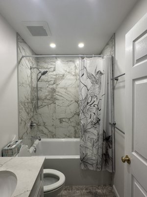 Guest Bathroom - After completing the master bath, we transformed this outdated guest bathroom, with old style soffit above the vanity, wallpaper  even in the shower area and outdated vanity.