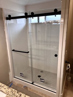 Double Sliding Door. Pleasant Grove, Utah 2025 - This install features a double sliding shower door with black hardware for a clean, modern look. The black hardware stands out nicely and the sliding doors make it easy to use from either side.
