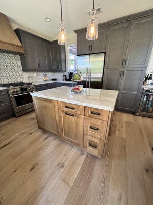Before and After Flooring and Kitchen Cabinet Remodel - Step into a home that has been completely reimagined from dated to dazzling. Originally featuring old, cold tile floors and yellow maple cabinets, this remodel breathes new life into the space with rich, warm hardwood flooring throughout. The kitchen underwent a remarkable upgrade with two-toned wood-stained cabinets, combining light and dark finishes for a modern yet timeless appeal. The seamless pairing of natural elements adds a cozy warmth to the home, creating an inviting sanctuary that’s as stylish as it is functional. It's an inspiring example of how thoughtful design choices and quality materials can transform any space into something extraordinary. Before and After Flooring and Kitchen Cabinet Remodel - Step into a home that has been completely reimagined from dated to dazzling. Originally featuring old, cold tile floors and yellow maple cabinets, this remodel breathes new life into the space with rich, warm hardwood flooring throughout. The kitchen underwent a remarkable upgrade with two-toned wood-stained cabinets, combining light and dark finishes for a modern yet timeless appeal. The seamless pairing of natural elements adds a cozy warmth to the home, creating an inviting sanctuary that’s as stylish as it is functional. It's an inspiring example of how thoughtful design choices and quality materials can transform any space into something extraordinary.