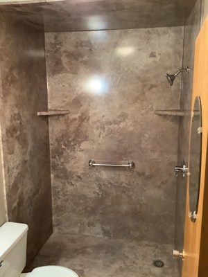 Madison, SD Shower/Tub Combo Transformation designed by Five Star Bath Solutions of Sioux Falls - Five Star Bath Solutions of Sioux Falls completed a tub-to-shower conversion in Madison, South Dakota, transforming an outdated tub/shower combo into a sleek, modern walk-in shower. The new design features practical corner shelving and sturdy grab bars, blending style with safety and functionality. The Everest wall color brings a fresh, contemporary look to the space. Our customer is thrilled with their upgraded bathroom and now enjoys a more open, accessible, and modern shower experience.