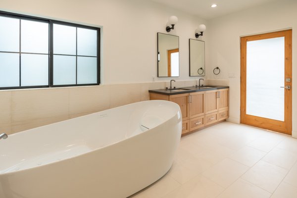 Bathroom Remodel Pasadena - This luxurious master bathroom remodel in an upscale home features high-end finishes and thoughtful design elements to create a spa-like sanctuary. The floor is laid with exquisite natural stone, providing a solid, elegant base that complements the overall aesthetic. A centerpiece of the design is the expansive shower, designed to accommodate two people comfortably. It includes dual shower heads and separate controls, allowing for a personalized bathing experience tailored to each individual's preference.

Adding to the opulence, the bathroom boasts a Toto zero-gravity tub, known for its therapeutic qualities and exceptional comfort, making it a perfect retreat for relaxation and rejuvenation. The custom vanity, tailored to the homeowners' specifications, enhances the functionality while contributing to the room's sophisticated look.

A unique feature of this master bathroom is its direct access to a private courtyard, providing an intimate connection with the outdoors and inviting natural light into the space. This setup not only enhances the serene, tranquil feel of the bathroom but also adds an element of indoor-outdoor living that is both luxurious and inviting. This master bathroom is a true testament to luxury and thoughtful design, making it a perfect retreat within the home.