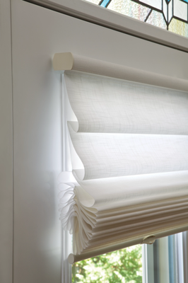 Roman Shades - Roman shades are a type of window treatment made from fabric that folds into neat horizontal pleats or a flat panel when raised, creating a soft and elegant look. They offer a balance of light control and privacy and are available in a wide array of fabrics and styles, including flat, hobbled (or soft) folds, and natural woven materials like bamboo or grass cloth. Unlike blinds, which have slats, Roman shades are a continuous fabric that can be customized with different linings for light filtering, insulation, or complete blackout.