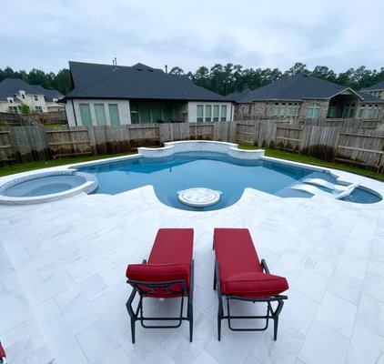 White marble pool - This pool has it all.  Tanning shelf, in water table and stools, spa, covered patio, outdoor kitchen, tv brick wall and a fire pit.  We also have step lights and a retaining wall.  To top it all off the whole project is all white marble.  Get your sunglasses ready!!!