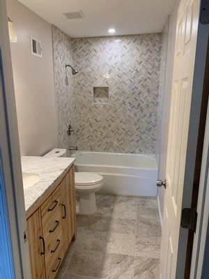 Standard Bathroom Remodel - This is a small bathroom we just completed in Alexandria. The homeowners chose mosaic tile for the shower walls and unique wooden bathroom vanity. When we started the bathroom was slightly smaller with 22" bathroom vanity. The homeowners wanted to have a slightly bigger bathroom. We knocked down a small bulk on the right side of the door and took roughly 4 SF of space from the closet in order to increase the size of the bathroom. This did not add a lot of extra space, but added the space necessary to fit a bigger bathroom vanity. Let us know if you have any upcoming projects and if you need professional help!