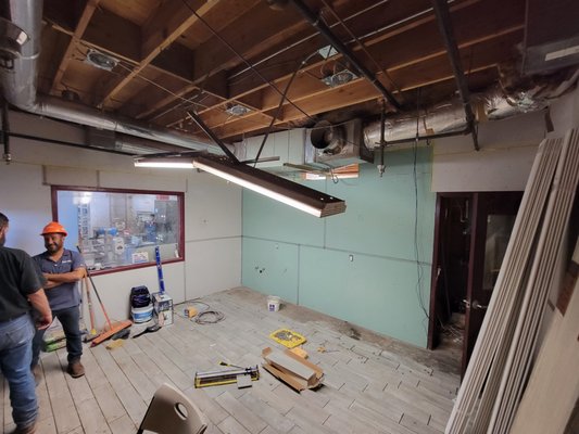 Commercial Breakroom - We hung the missing sheetrock. Mesh tape and mud for all joints and angles. Then we applied our signature AKC skip trowel texture. We proceeded to paint the walls, ceiling, pipes, trim, doors, cabinets, and shiplap. What a transformation!