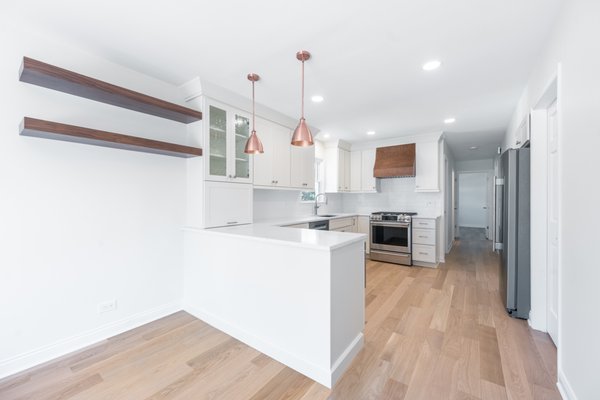 Chicago Kitchen Remodel - A full kitchen home renovation in Chicago featuring soft white cabinetry, quartz countertops, warm oak flooring, and copper pendant lighting for a bright, welcoming space to cook and gather. Chicago Kitchen Remodel - A full kitchen home renovation in Chicago featuring soft white cabinetry, quartz countertops, warm oak flooring, and copper pendant lighting for a bright, welcoming space to cook and gather.