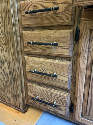 Kitchen cabinet refinishing - This kitchen had oak cabinets that had water damage. We sanded them removing the water damage, and old stain. Then we used a quality oil based stain, and clear coat for a long lasting finish. Then we also added new cabinet handles where there were none before.