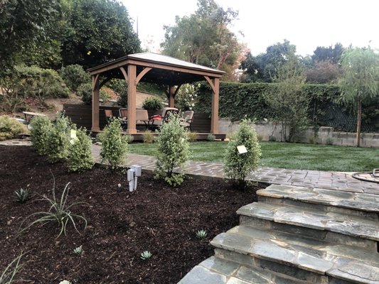 Paradise - This gorgeous landscaping is designed to create a vibrant landscape against the natural stone walkways. Makes this slopped area usable and bright.