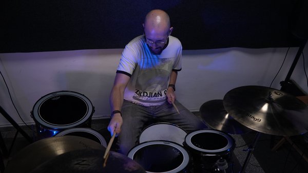 Meet Your Instructor - Influenced by his family, Robbie’s passion for drumming began at age 8 with a simple practice pad and sticks, guided by lessons from his grandmother. By 13, he had moved to the drum set, developing a deep connection to rhythm and music.
Over the past 20 years, Robbie has earned an Associate of Arts in Music Performance from Musicians Institute in Hollywood and studied under renowned drummers including Tommy Igoe, John Xepoleas, Rob Carson, and Fred Dinkins. His performance experience spans both original and cover bands, exploring styles such as rock, blues, reggae, funk, jazz, R\&B, and punk.
Since beginning his teaching career at School of Rock in 2016, Robbie has worked with students of all ages and skill levels. Many of his students have gone on to join bands, while others have pursued careers in music. His teaching approach blends the best of what he’s learned from legendary mentors, focusing on practical methods that deliver results.
Robbie teaches everyone from beginners to professionals using a carefully designed, holistic method. By covering rudiments, technique, reading, timekeeping, and more, his students gain clarity, progress faster, and most importantly—enjoy the process. Through his teaching, Robbie shares not only his expertise but also his lifelong passion for drums and the joy that music brings.
Drum power! Meet Your Instructor - Influenced by his family, Robbie’s passion for drumming began at age 8 with a simple practice pad and sticks, guided by lessons from his grandmother. By 13, he had moved to the drum set, developing a deep connection to rhythm and music.
Over the past 20 years, Robbie has earned an Associate of Arts in Music Performance from Musicians Institute in Hollywood and studied under renowned drummers including Tommy Igoe, John Xepoleas, Rob Carson, and Fred Dinkins. His performance experience spans both original and cover bands, exploring styles such as rock, blues, reggae, funk, jazz, R\&B, and punk.
Since beginning his teaching career at School of Rock in 2016, Robbie has worked with students of all ages and skill levels. Many of his students have gone on to join bands, while others have pursued careers in music. His teaching approach blends the best of what he’s learned from legendary mentors, focusing on practical methods that deliver results.
Robbie teaches everyone from beginners to professionals using a carefully designed, holistic method. By covering rudiments, technique, reading, timekeeping, and more, his students gain clarity, progress faster, and most importantly—enjoy the process. Through his teaching, Robbie shares not only his expertise but also his lifelong passion for drums and the joy that music brings.
Drum power!