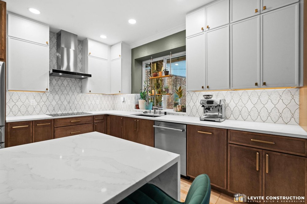 Kitchen Remodel with a nice mosaic pattern backsplash and custom white and wood stain cabinetry with led light.