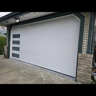 Garage door replacement & upgrade - This sleek garage door with left-aligned vertical windows brings a modern edge to any home. The clean lines and minimalist design not only elevate the look, also lets in natural light without giving up privacy.