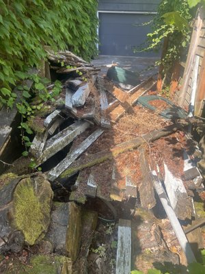 Pile of wood and tree stumps on side of garage - We had a new home owner who wanted all of the extra wood and dirt on the side of their garage removed. Pile of wood and tree stumps on side of garage - We had a new home owner who wanted all of the extra wood and dirt on the side of their garage removed.