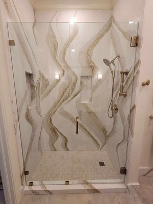Shower Remodel 2025 - Stunning shower remodel featuring beautiful gold accents and glass doors.