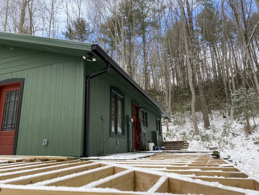 Upper Stone Mountain Gutter 2025 - This was a new build on Upper Stone Mountain in Unicoi,TN. We installed 6” gutters and downspouts and also installed gutter guard. As you can see, we were greeted with falling snow on the mountain during the job. Really excited how the black gutters popped on the green siding on this cozy little home.