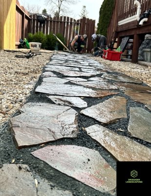 Flagstone Walkway Rejuvenation - We had lots of fun with this smaller project, Took my guys only 2 days to complete.
We removed existing flagstone pavers to inspect the basework, alot of sinking and gaps you can see through the before photos.
After removing the pavers, we went ahead and inspected the basework , repaired the basework and brought the walkway back to the proper height, while keeping water drainage in mind.
Carefully replacing the pavers back in the correct pattern to uphold its authentic aesthetic.
We then added black granite 1/4 to act as a fill and to give the rustic walkway a more modern look.
After completing the walkway, we readjusted the Riverstone all around and re graded it to complete the final look. Flagstone Walkway Rejuvenation - We had lots of fun with this smaller project, Took my guys only 2 days to complete.
We removed existing flagstone pavers to inspect the basework, alot of sinking and gaps you can see through the before photos.
After removing the pavers, we went ahead and inspected the basework , repaired the basework and brought the walkway back to the proper height, while keeping water drainage in mind.
Carefully replacing the pavers back in the correct pattern to uphold its authentic aesthetic.
We then added black granite 1/4 to act as a fill and to give the rustic walkway a more modern look.
After completing the walkway, we readjusted the Riverstone all around and re graded it to complete the final look.