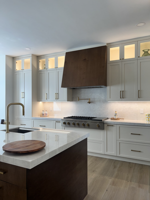Kitchen Remodel — Cutler Bay - This kitchen renovation embodies both form and function — the two-toned cabinetry, a combination of sleek white shaker cabinets and rich wood-toned slabs, creates a modern aesthetic with a touch of warmth.

Both the island and peninsula are equipped with sinks for easy prep work, while the island boasts a built-in microwave drawer for added convenience. 

The polished marble countertops extend up the walls as a full backsplash, creating a cohesive and visually expansive feel throughout the kitchen.