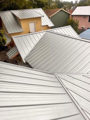 Galvalume Standing Seam Metal Roof | Historic Home Renovation – Winter Park, FL - Our team recently completed a beautiful new standing seam metal roof as part of a full historic home renovation and detached garage addition in Winter Park, Florida. We installed a 26-gauge galvalume system with concealed fasteners, providing a clean, modern look that complements the character of the home while delivering superior long-term protection.
This roof is built to perform in Florida’s climate, offering excellent wind resistance, energy efficiency, and corrosion protection. Special care was taken to preserve the architectural integrity of the property, maintain proper waterproofing details, and ensure all work met current Florida Building Code standards.
The finished result is a durable, high-end roof system that enhances both the curb appeal and value of this historic Winter Park residence. Galvalume Standing Seam Metal Roof | Historic Home Renovation – Winter Park, FL - Our team recently completed a beautiful new standing seam metal roof as part of a full historic home renovation and detached garage addition in Winter Park, Florida. We installed a 26-gauge galvalume system with concealed fasteners, providing a clean, modern look that complements the character of the home while delivering superior long-term protection.
This roof is built to perform in Florida’s climate, offering excellent wind resistance, energy efficiency, and corrosion protection. Special care was taken to preserve the architectural integrity of the property, maintain proper waterproofing details, and ensure all work met current Florida Building Code standards.
The finished result is a durable, high-end roof system that enhances both the curb appeal and value of this historic Winter Park residence.