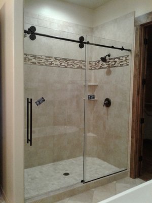 Sliding Glass Door Shower Enclosure - The owner's renovated their bathroom including a re-tiled shower. Our team designed and installed a sliding glass door with minimal hardware to achieve a modern look and feel. Sliding Glass Door Shower Enclosure - The owner's renovated their bathroom including a re-tiled shower. Our team designed and installed a sliding glass door with minimal hardware to achieve a modern look and feel.