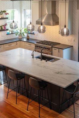 Boulder County Luxury Kitchen Remodel | Custom Design-Build Transformation - This Boulder County kitchen remodel blends timeless design with modern functionality, creating a space that is both beautiful and highly practical for everyday living.
The design features custom Dove White cabinetry paired with a White Oak stained island, creating a warm contrast that adds character and depth. Infinity White honed quartzite countertops and Black Tempal quartz perimeter surfaces provide durability and sophistication, while a honed Bianco Dolomite chevron backsplash introduces texture and visual interest.
Custom details throughout the space make this kitchen truly unique, including a hidden pop-up outlet, two-tone cabinetry, and a custom arched opening designed and built by our in-house design-build team. Black fixtures and clean architectural lines complete the look, resulting in a kitchen that feels refined, functional, and built to stand the test of time.
This project showcases the collaborative approach between Boulder Design Group and Veron Builders, bringing design and construction together from concept to completion for a seamless remodeling experience.
Location: Boulder County, Colorado Boulder County Luxury Kitchen Remodel | Custom Design-Build Transformation - This Boulder County kitchen remodel blends timeless design with modern functionality, creating a space that is both beautiful and highly practical for everyday living.
The design features custom Dove White cabinetry paired with a White Oak stained island, creating a warm contrast that adds character and depth. Infinity White honed quartzite countertops and Black Tempal quartz perimeter surfaces provide durability and sophistication, while a honed Bianco Dolomite chevron backsplash introduces texture and visual interest.
Custom details throughout the space make this kitchen truly unique, including a hidden pop-up outlet, two-tone cabinetry, and a custom arched opening designed and built by our in-house design-build team. Black fixtures and clean architectural lines complete the look, resulting in a kitchen that feels refined, functional, and built to stand the test of time.
This project showcases the collaborative approach between Boulder Design Group and Veron Builders, bringing design and construction together from concept to completion for a seamless remodeling experience.
Location: Boulder County, Colorado