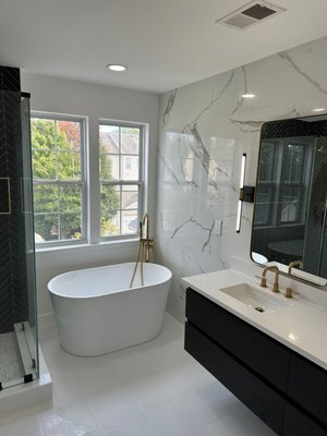 Bathroom Remodeling - Embark on a journey of sophistication and modern elegance with our bathroom remodeling project featuring exquisite gold fixtures and sleek black details