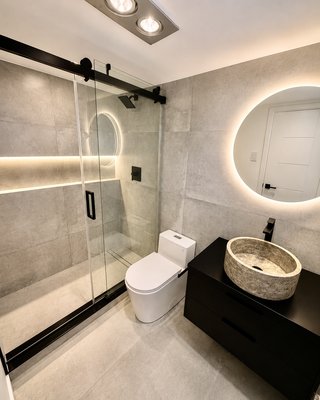 Lighting Up Luxury: A Modern Bathroom Transformation by Axetron - Great design is in the details you don’t notice until you step inside.
For this project, we brought a clean, hotel-worthy aesthetic into a private home. From large-format porcelain tile with 45° mitered edges to custom built-in LED lighting integrated right into the shower ledges and niches — every corner was built for maximum relaxation.
Key features:
1. Custom wall-to-wall illuminated shower ledge
2. Floating black vanity with a raw natural stone vessel sink
3. Backlit ambient round mirror & designer lighting
4. Sleek matte black hardware & frameless sliding glass enclosure
Ready to elevate your bathroom into a modern spa? Reach out to our team today for a custom consultation! Lighting Up Luxury: A Modern Bathroom Transformation by Axetron - Great design is in the details you don’t notice until you step inside.
For this project, we brought a clean, hotel-worthy aesthetic into a private home. From large-format porcelain tile with 45° mitered edges to custom built-in LED lighting integrated right into the shower ledges and niches — every corner was built for maximum relaxation.
Key features:
1. Custom wall-to-wall illuminated shower ledge
2. Floating black vanity with a raw natural stone vessel sink
3. Backlit ambient round mirror & designer lighting
4. Sleek matte black hardware & frameless sliding glass enclosure
Ready to elevate your bathroom into a modern spa? Reach out to our team today for a custom consultation!